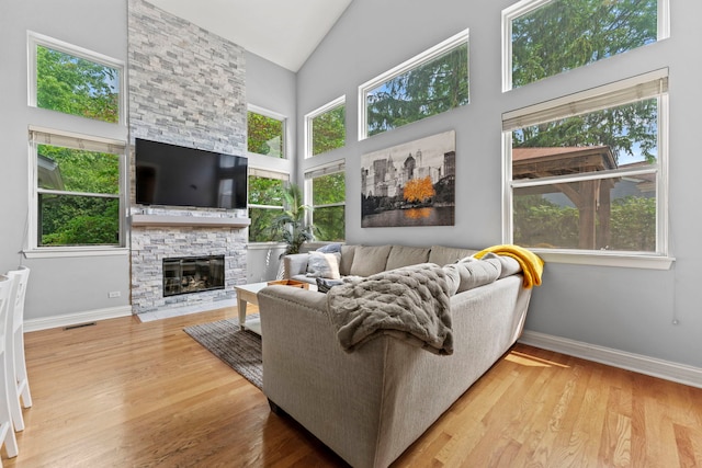 1132 Locust Ct, Bartlett, IL 60103 - living room with healthy amount of natural light, wood finished floors, high vaulted ceiling, and a stone fireplace