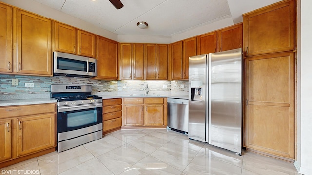 720 Prestwick Ln Unit 207, Wheeling, IL 60090 - kitchen with stainless steel appliances, a sink, light countertops, decorative backsplash, and brown cabinets