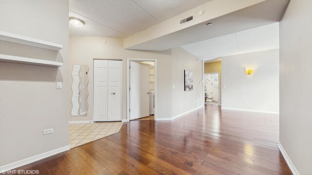 720 Prestwick Ln Unit 207, Wheeling, IL 60090 - empty room featuring wood-type flooring, baseboards, and a textured ceiling