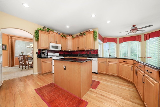 25014 W Nicklaus Way, Antioch, IL 60002 - kitchen featuring white appliances, light wood finished floors, a center island, decorative backsplash, and dark countertops