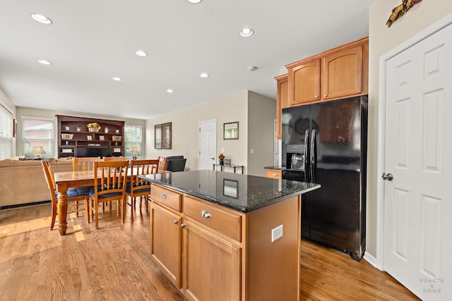 11582 Beacon Ave, Huntley, IL 60142 - kitchen featuring black fridge with ice dispenser, a kitchen island, light wood-type flooring, recessed lighting, and dark stone countertops