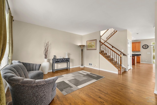 11582 Beacon Ave, Huntley, IL 60142 - living room with stairway, light wood-style floors, and baseboards