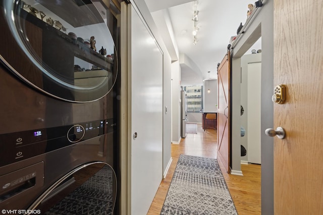 208 W Washington St Unit 1205, Chicago, IL 60606 - washroom with stacked washer / dryer, a barn door, and light wood finished floors