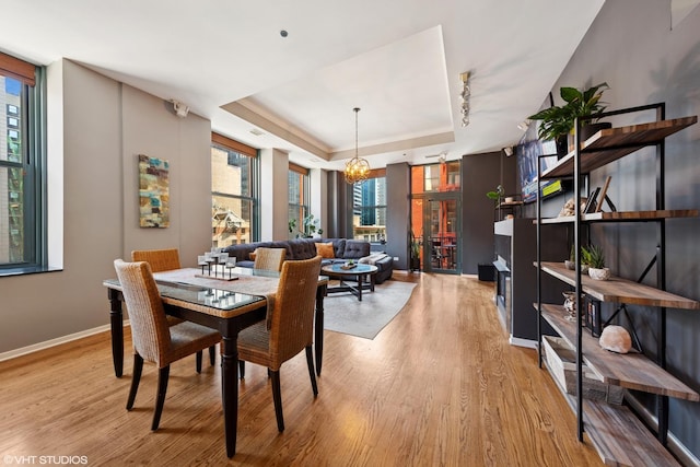 208 W Washington St Unit 1205, Chicago, IL 60606 - dining area featuring a raised ceiling, plenty of natural light, and light wood-style floors