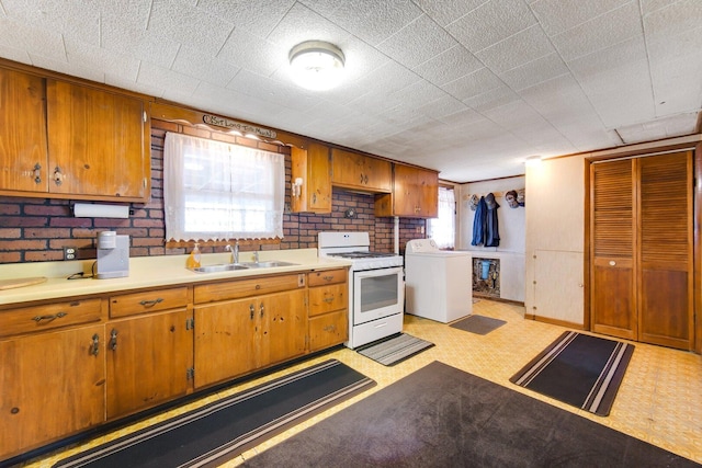 16419 W 147th Pl, Lockport, IL 60441 - kitchen with white gas stove, washer / clothes dryer, a sink, light flooring, and brown cabinets