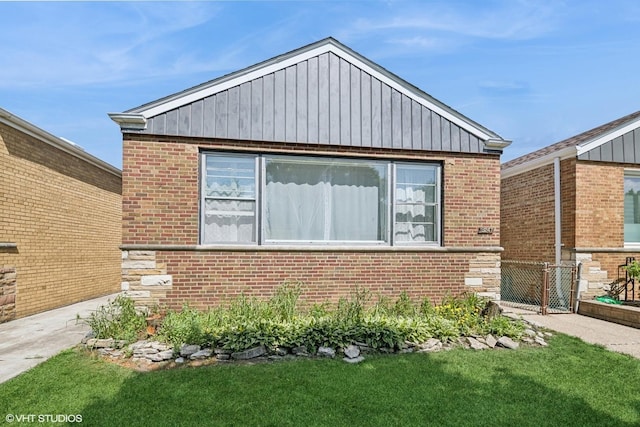 5247 N California Ave, Chicago, IL 60625 - view of home's exterior with brick siding, board and batten siding, and a yard