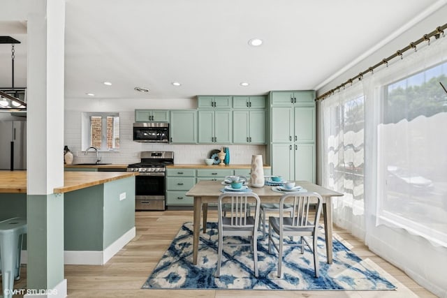 5247 N California Ave, Chicago, IL 60625 - kitchen with butcher block countertops, appliances with stainless steel finishes, green cabinetry, plenty of natural light, and recessed lighting