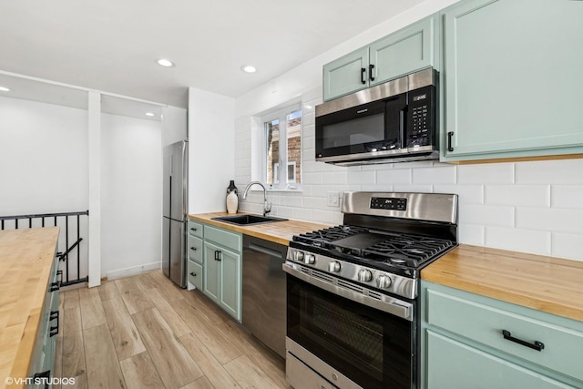 5247 N California Ave, Chicago, IL 60625 - kitchen with wooden counters, appliances with stainless steel finishes, light wood-type flooring, tasteful backsplash, and recessed lighting