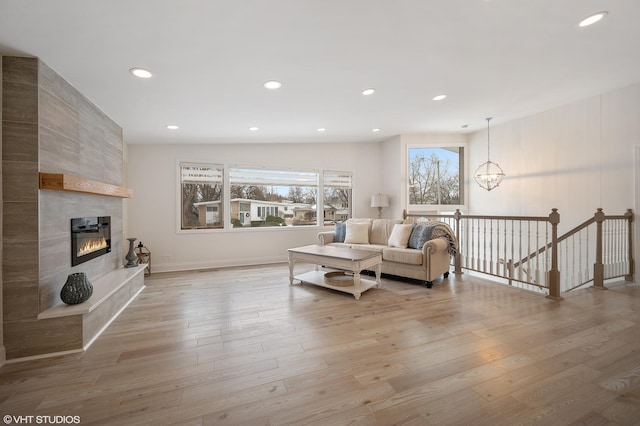 316 Nellie Ct, Glenview, IL 60025 - living room featuring a tiled fireplace, light wood-style floors, recessed lighting, and a chandelier