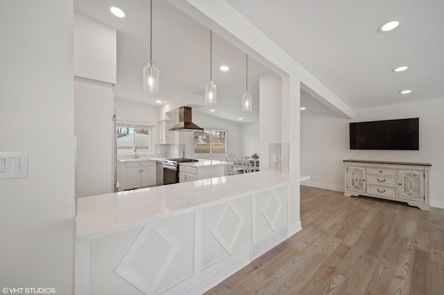 316 Nellie Ct, Glenview, IL 60025 - kitchen with wall chimney range hood, stainless steel range with gas stovetop, recessed lighting, light countertops, and light wood-style flooring