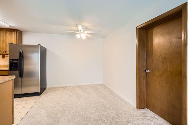 117 Cotuit Ct Unit 117, Schaumburg, IL 60193 - kitchen with stainless steel fridge, ceiling fan, light countertops, brown cabinetry, and light carpet