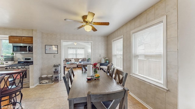 1910 N 76th Ct, Elmwood Park, IL 60707 - dining room featuring light tile patterned flooring, a ceiling fan, and tile walls