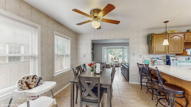 1910 N 76th Ct, Elmwood Park, IL 60707 - dining room featuring light tile patterned flooring, tile walls, and ceiling fan