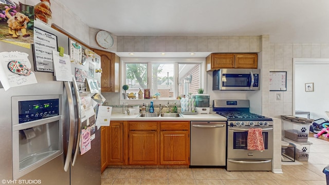 1910 N 76th Ct, Elmwood Park, IL 60707 - kitchen featuring stainless steel appliances, a sink, light tile patterned flooring, brown cabinetry, and light countertops