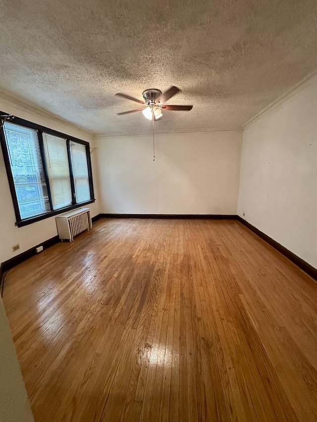 1453 W Elmdale Ave Unit 1, Chicago, IL 60660 - unfurnished room with radiator, a ceiling fan, a textured ceiling, wood finished floors, and baseboards
