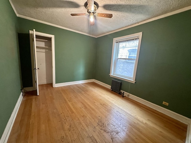 1453 W Elmdale Ave Unit 1, Chicago, IL 60660 - unfurnished bedroom featuring a textured ceiling, wood finished floors, baseboards, radiator, and crown molding