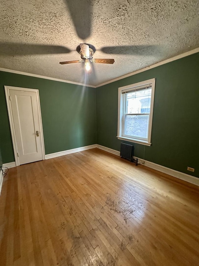 1453 W Elmdale Ave Unit 1, Chicago, IL 60660 - empty room featuring radiator, hardwood / wood-style flooring, a textured ceiling, ornamental molding, and ceiling fan