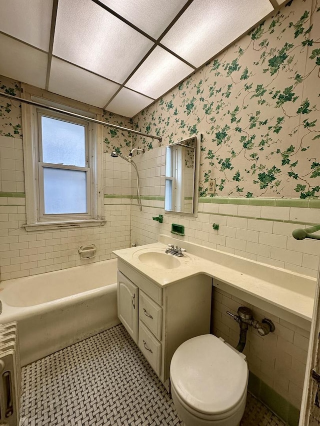 1453 W Elmdale Ave Unit 1, Chicago, IL 60660 - bathroom featuring vanity, tile walls, wainscoting, shower / bath combination, and tile patterned floors