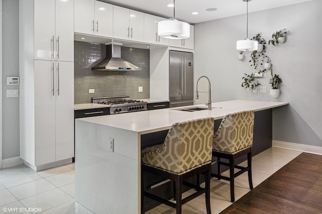 1350 W Diversey Pkwy Unit 1, Chicago, IL 60614 - kitchen with wall chimney exhaust hood, high end fridge, tasteful backsplash, stove, and a kitchen bar