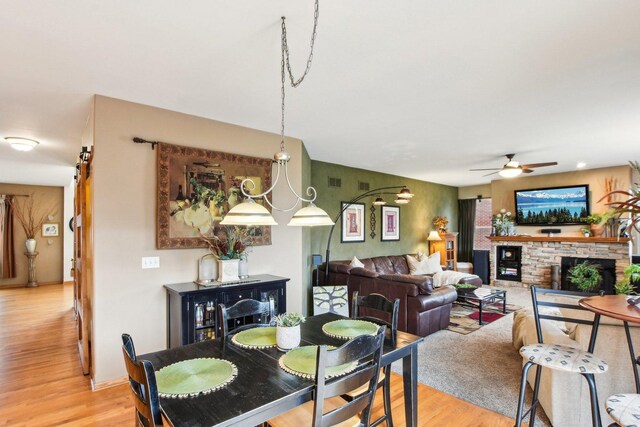 949 Ruthenbeck Ln, New Lenox, IL 60451 - dining space with light wood finished floors, ceiling fan, and a fireplace