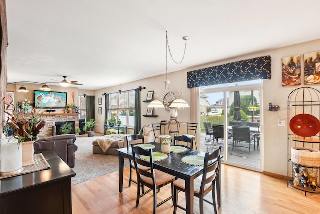 949 Ruthenbeck Ln, New Lenox, IL 60451 - dining space featuring a ceiling fan, light wood-type flooring, and a fireplace