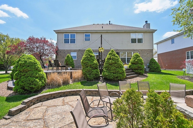 949 Ruthenbeck Ln, New Lenox, IL 60451 - back of property with a chimney, brick siding, a patio, and a lawn