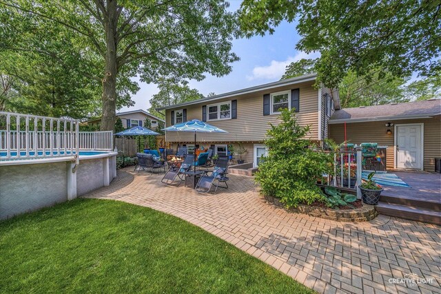 124 Fairview Dr, Saint Charles, IL 60174 - rear view of property featuring a deck, an outdoor pool, and a patio