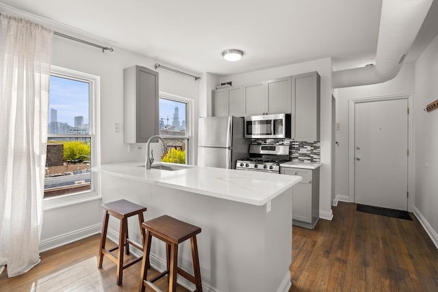 1322 W Huron St Unit 4N, Chicago, IL 60642 - kitchen with appliances with stainless steel finishes, gray cabinets, dark wood-style floors, and a breakfast bar area