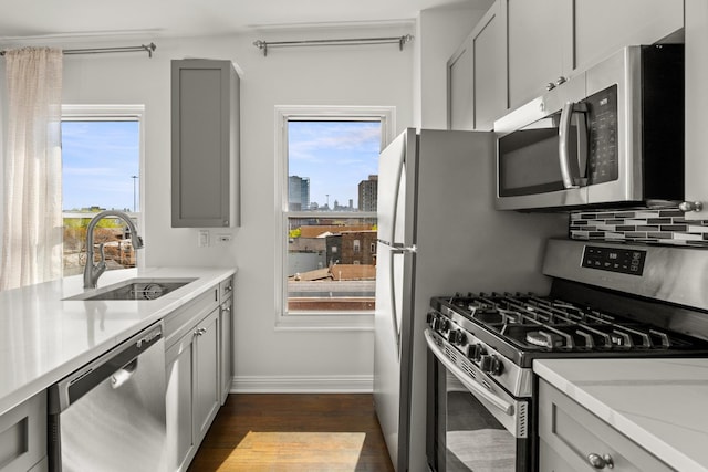 1322 W Huron St Unit 4N, Chicago, IL 60642 - kitchen featuring appliances with stainless steel finishes, dark wood finished floors, gray cabinets, light countertops, and backsplash