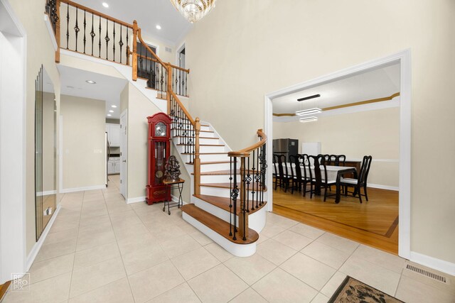 401 Jason Ln, Schaumburg, IL 60173 - stairway with tile patterned flooring, a chandelier, a high ceiling, and recessed lighting