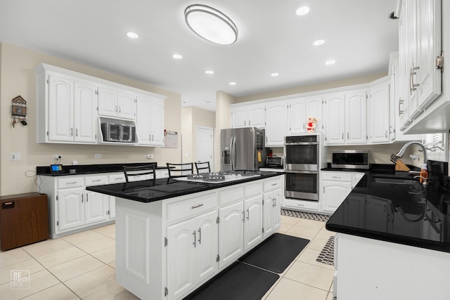 401 Jason Ln, Schaumburg, IL 60173 - kitchen featuring stainless steel appliances, light tile patterned floors, a center island, white cabinets, and dark countertops