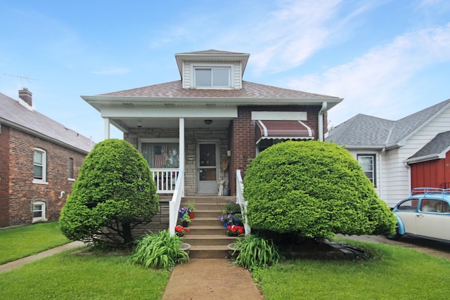 2424 Birch Ave, Whiting, IN 46394 - bungalow-style home featuring covered porch, a front yard, roof with shingles, and brick siding