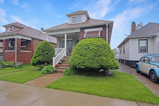 2424 Birch Ave, Whiting, IN 46394 - view of front facade with covered porch, brick siding, a front lawn, and roof with shingles