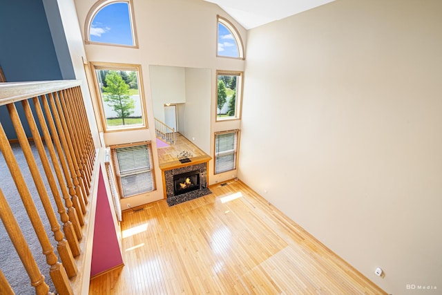9963 Constitution Dr, Orland Park, IL 60462 - unfurnished living room with healthy amount of natural light, a high ceiling, wood finished floors, stairway, and a fireplace