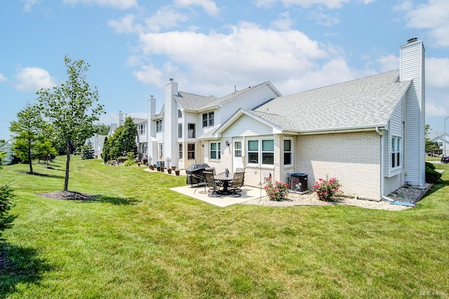9963 Constitution Dr, Orland Park, IL 60462 - back of property featuring a patio area, a lawn, brick siding, and a chimney