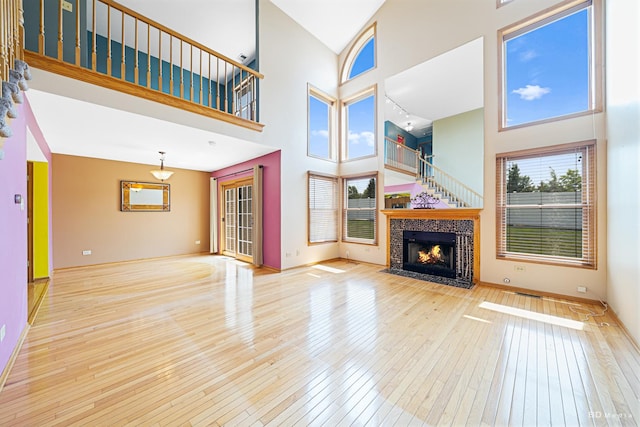 9963 Constitution Dr, Orland Park, IL 60462 - unfurnished living room featuring a towering ceiling, hardwood / wood-style flooring, and a tile fireplace