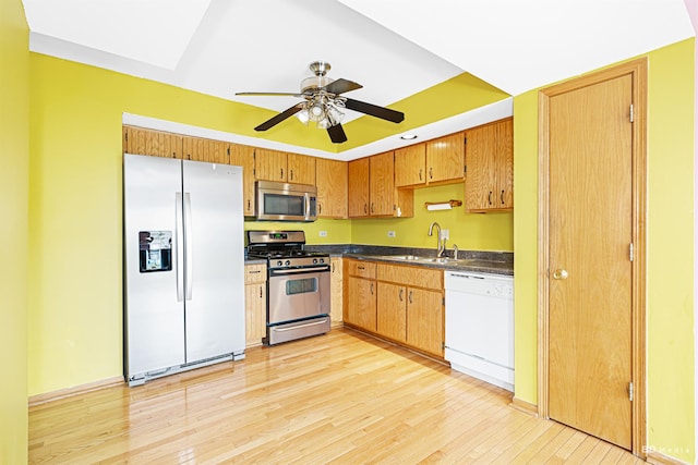 9963 Constitution Dr, Orland Park, IL 60462 - kitchen featuring stainless steel appliances, dark countertops, light wood finished floors, ceiling fan, and brown cabinets
