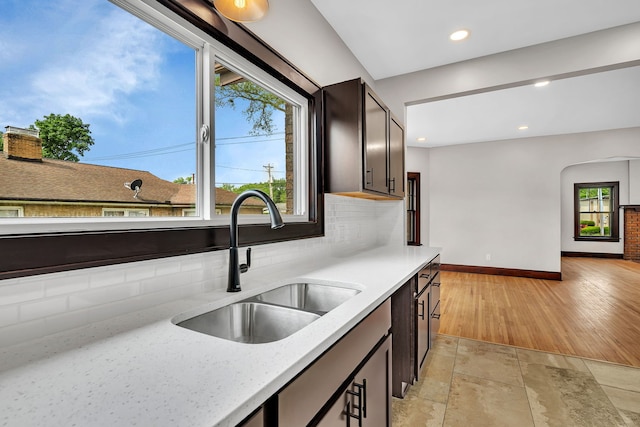 212 S Columbia Ave, Oglesby, IL 61348 - kitchen featuring tasteful backsplash, arched walkways, recessed lighting, light stone finish flooring, and light stone counters