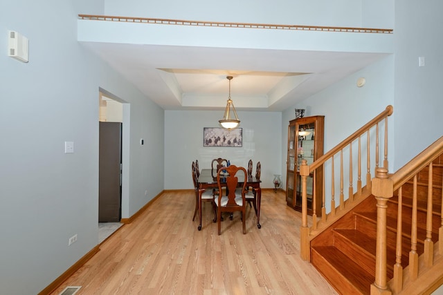 10935 Conifer Ct, Orland Park, IL 60467 - dining space with light wood-style floors, a raised ceiling, and stairway
