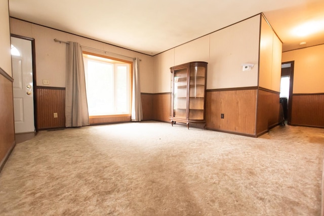 1602 N Jefferson Ave, Dixon, IL 61021 - unfurnished living room featuring a wainscoted wall, carpet floors, and wood walls