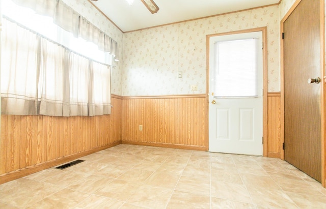 1602 N Jefferson Ave, Dixon, IL 61021 - unfurnished room featuring wainscoting, wallpapered walls, crown molding, and ceiling fan