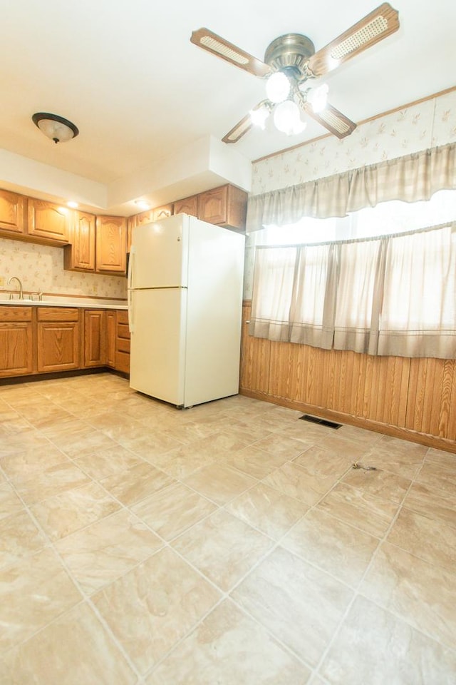 1602 N Jefferson Ave, Dixon, IL 61021 - kitchen with freestanding refrigerator, light countertops, ceiling fan, and brown cabinets