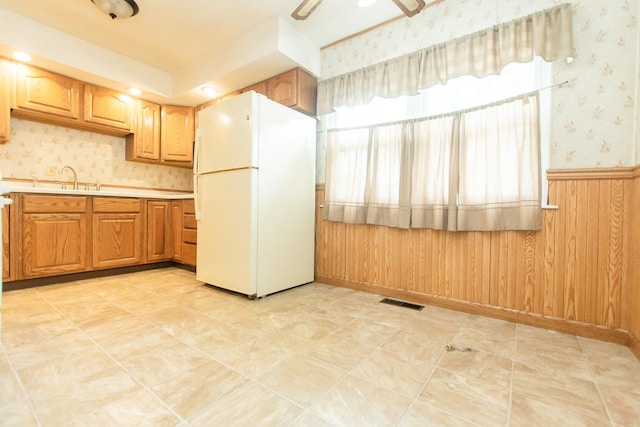 1602 N Jefferson Ave, Dixon, IL 61021 - kitchen featuring freestanding refrigerator, wallpapered walls, light countertops, a ceiling fan, and wooden walls