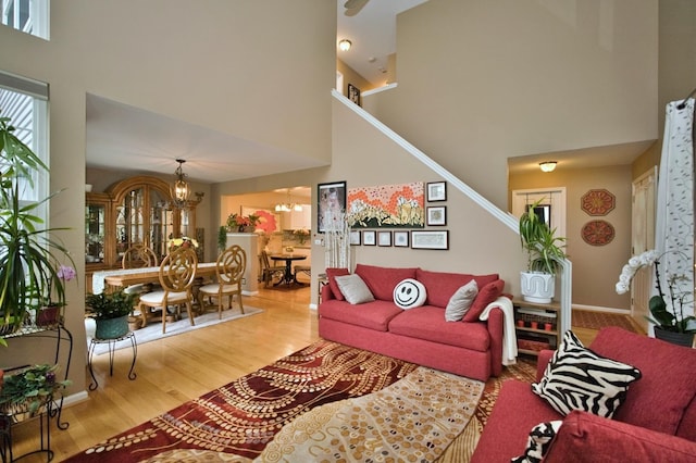 3944 Garnette Ct, Naperville, IL 60564 - living room featuring a towering ceiling, a chandelier, wood finished floors, and stairs