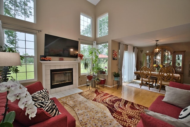 3944 Garnette Ct, Naperville, IL 60564 - living area featuring a fireplace, wood finished floors, a high ceiling, and a chandelier