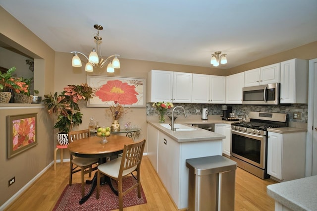 3944 Garnette Ct, Naperville, IL 60564 - kitchen featuring stainless steel appliances, light wood finished floors, a chandelier, a peninsula, and white cabinets