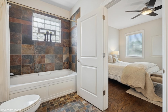 4110 N California Ave Unit 1, Chicago, IL 60618 - ensuite bathroom featuring shower / bathtub combination with curtain, plenty of natural light, a ceiling fan, and stone finish flooring