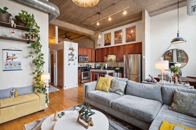 3963 W Belmont Ave Unit 137, Chicago, IL 60618 - living room featuring light wood-style floors, a towering ceiling, ceiling fan, and track lighting