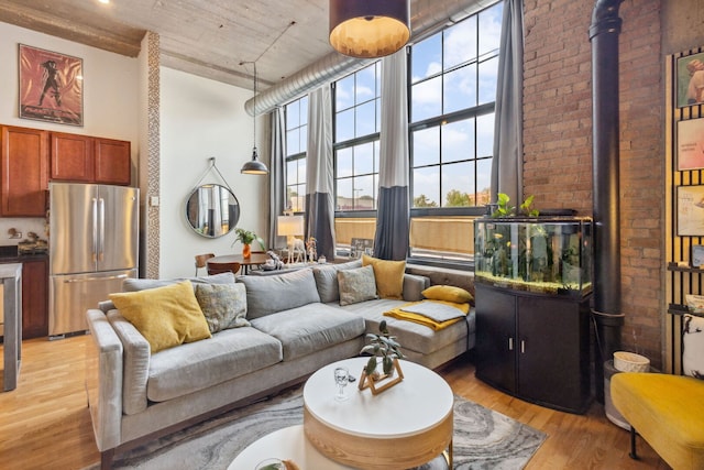 3963 W Belmont Ave Unit 137, Chicago, IL 60618 - living room featuring a towering ceiling, light wood-type flooring, healthy amount of natural light, and brick wall