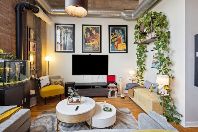 3963 W Belmont Ave Unit 137, Chicago, IL 60618 - living room with wood finished floors, a wood stove, and brick wall